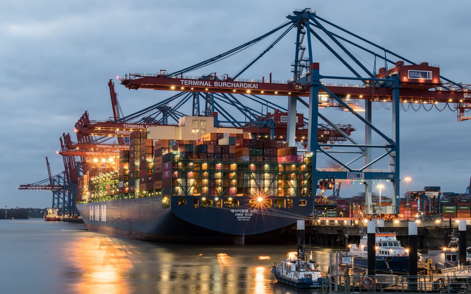Container ship being loaded at a port at dusk